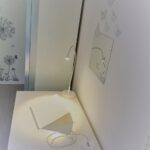 Comodino con lampada da lettura accanto al letto