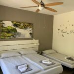 Camera con letto matrimoniale e singolo, ventilatore a soffitto colorato