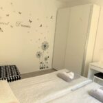 Camera con scritta Sweet Dreams, armadio a specchio e poltrona