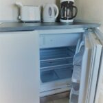 Frigorifero, macchina del caffe, bollitore e tostapane in cucina