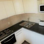 Cucina moderna con piano cottura a induzione, forno, microonde, tostapane e bollitore