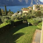 Giardino con prato verde, vista su Malcesine e campanile