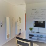 Zona soggiorno con TV a schermo piatto e mobile porta TV